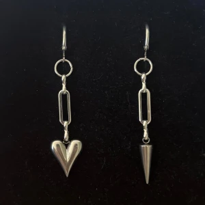 Silvriga örhängen med hjärta och nitar - Handgjorda och unika silverörhängen 🤩 Öronhängerna är nickelfria och silverpläterade i kirurgiskt stål, resterande av örhänget är i rostfritt stål (ej silverpläterat) 💕🙏 5 cm långa. 