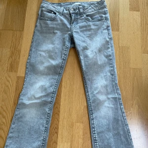 grå low waist jeans - gråa low waist jeans som går utåt längst ner från gina tricot, storlek 38, köptes för ca 400kr, pris kan diskuteras.