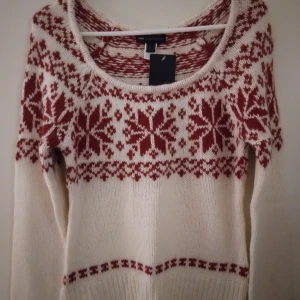 HELT NY Vit och röd stickad tröja / jultröja från Mango / MNG,  XS-S - HELT NY & OANVÄND mysig mjuk stickad vit tröja från MNG  med rött nordiskt mönster/julmönster, Storlek XS-S. Rund halsringning och långa ärmar. Perfekt för kalla dagar och har snygga detaljer med snöflingor och klassiska vintervibbar. Ribbstickad nederkant och ärmslut för extra komfort.