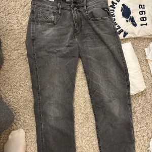 Replay grå jeansbyxor waist 29/32 - Snygga grå jeansbyxor från Replay med klassisk femficksdesign och svarta detaljer på bakfickan. Modellen har rak passform och är tillverkad i mjukt jeanstyg som sitter skönt. Perfekt för dig som gillar stilrena och tidlösa jeans.