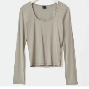 Beige långärmad topp från Gina Tricot - Säljer en stilren beige långärmad topp från Gina Tricot i storlek XS. Toppen har en rundad halsringning och är croppad i modellen. Materialet är mjukt och stretchigt, perfekt för att matcha med jeans eller kjol. Enkelt och snyggt plagg för din garderob.