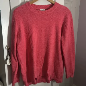 Rosa stickad tröja från Gerry Weber - Mysig rosa stickad tröja från Gerry Weber med rund halsringning och ribbade muddar. Tröjan har en enkel design med en liten slitsdetalj nertill och är perfekt för lager-på-lager under kyliga dagar. Använd endast när jag fick den ‼️ Super snygg med en annorlunda färg vilket jag gillar och den är lite oversized så man kan använda en tröja under 🥰
