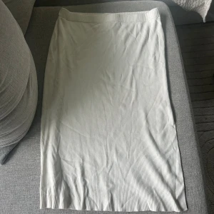 Stickad kjol. - Fin stickad kjol med slits, aldrig använd. Passar personer med XXL också.
