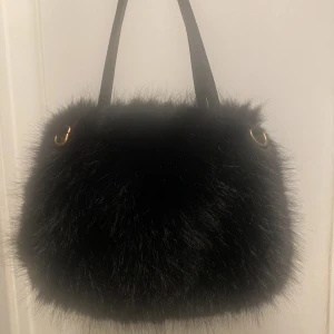 Svart fluffig axelväska med päls - Svart fluffig päls, inte äkta päls. Använd en gång. Finns långt band till! :) 