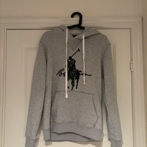 Ralph Lauren Hoodie - Säljer denna gråa Ralph Lauren hoodie i nytt skick!! | Använd 1 gång! | Storlek M | Osäker på äktheten därav priset! | Pris går att diskutera vid snabb affär! | Hör av dig vid minsta fundering! |