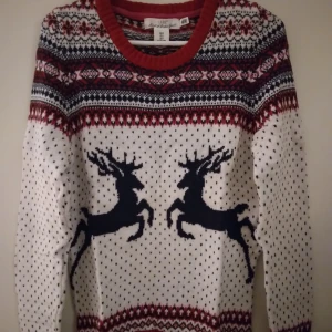 HELT NY OANVÄND Vit stickad tröja/ Jultröja med renmotiv från H&M LOGG. Small. - Helt ny och oanvänd stickad jultröja från H&M LOGG med klassiskt mönster i vitt, rött och marinblått. Stirlek Small. Tröjan har långa ärmar, rund hals och två stora renar framtill. Perfekt för dig som vill maxa julkänslan med snyggt mönster och färgkombination. Felfri.
