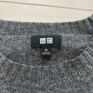 Grå stickad tröja — Uniqlo - Stilren grå stickad tröja från Uniqlo i storlek XS. Perfekt för kyliga dagar. I nyskick, inga hål eller liknande defekter. Längd: 62 cm. Jag är 179 på bilden väger 67-68. 
