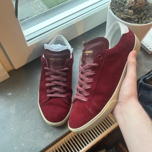 Saint Laurent skor - (Intressekoll) Snygga vinröda sneakers från Saint Laurent i sjukt bra skick, storlek 42 passar även 43. Dustbag och skor kommer med. Hör av er om ni undrar över något!😇