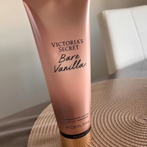 Victoria's Secret Bare Vanilla lotion - Fragrance lotion Bare Vanilla från Victoria's Secret i en snygg roséguldig tub med svart och guldigt lock. Innehåller 236 ml och har en doft av vispad vanilj och mjuk cashmere. Vegansk formula och tillverkad med återvunnen plast. Perfekt för dig som älskar söta dofter.