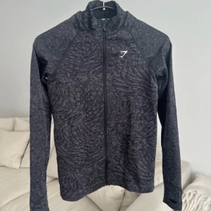 Träningsjacka från Gymshark - Gymshark Adapt Animal Print träningströja, storlek XS. Supersnygg och i ett stretchigt material. Säljer då den är lite stor på mig, skulle annars gärna behålla. Har aldrig använts, endast tvättats <3