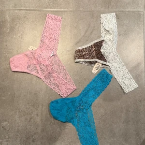 3 spetsstring Victoria's Secret - Säljer 3 par stringtrosor från Victoria's Secret i spets. En är ljusrosa, en är turkosblå och en har leopardmönster med vit spetskant. Alla är stretchiga och har bred spets i midjan.  Sjävklart aldrig använda. Prislappar på. Kostade  16$ styck.