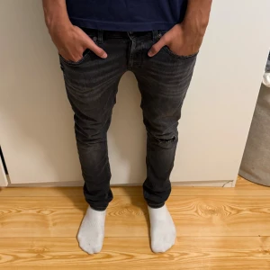 Dondup george - Snygga mörkgrå/ svarta jeans från Dondup modellen George med skinny passform och slitning vid knät. Nyskick använd max 5 gånger, nypris-4000 mitt pris-899, pris kan diskuteras