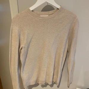 Beige Crewneck - En stilren beige stickad tröja med rund halsringning och långa ärmar. Tröjan har en enkel och klassisk design som passar perfekt till vardags. Mjuk och skön att bära, perfekt för lager-på-lager. Hör av dig vid funderingar😁