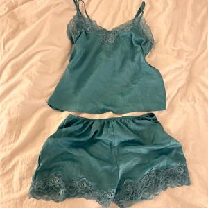 Pyjamas sett blå S/M  - Säljer ett jättefint blått sett me satinmaterial och spetsdetaljer. Använder aldrig så den är i nyskick 