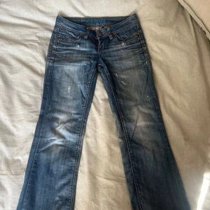 Blå lowwaist bootcut jeans från ONLY W27 L32 - Jättesnygga lågmidjade jeans från ONLY med bootcut-modell och slitna detaljer som tyvärr blivit för små. Lite slitna längst ner men ingenting man tänker på! 