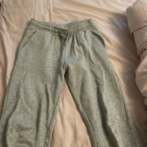 Grå mjukisbyxor från Ullared  - Grå mjukisbyxor från ullared med resår i midjan och raka ben. Byxorna har sidfickor, perfekta för chill dagar. Passar dig som gillar en avslappnad och enkel stil. sl 145-152