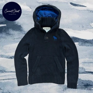 Mörkblå stickad hoodie Abercrombie - Mörkblå stickad hoodie från Abercrombie & Fitch med blått älglogga på bröstet | Size S/ Xs | Längd: 62cm Axelbredd: 35cm