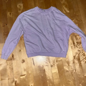 Ljuslila sweatshirt - Tröjan har ribbade muddar vid ärmslut och nederkant, med rund hals. Den är petite i storlek 40-42 men passar som en vanlig S/36