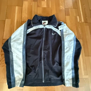 Nike Track Jacket Oversized  - Begagnad köpt från en Brittisk Thrifted butik, men passade inte dp det stod att storleken skulle vara 14-16 år. Men är 16-18 år polyester jacka.