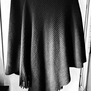 Svart finstickad poncho från Soyaconcept! - Svart finstickad poncho med stor krage och fransar från Soyaconcept. Längd från axel till längsta del 100 cm. I mycket fint skick!
