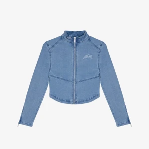 Blå croppad jeansjacka med dragkedja - Snygg croppad jeansjacka från PXR i ljusblå denim. Jackan har hög krage, dragkedja framtill och diskret broderad logga på bröstet. Långa ärmar med dragkedjor vid ärmslut ger en cool touch. Perfekt för dig som vill sticka ut med en modern look.
