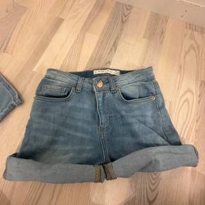 Ljusblå jeansshorts från Mavi  - Snygga ljusblå jeansshorts från Amisu med klassisk femficksdesign och uppvikta benslut. Perfekta för varma dagar och enkla att matcha med allt. De har en normal passform och är tillverkade i mjukt denimtyg.