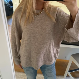 Beige stickad tröja - Mysig beige stickad tröja med avslappnad passform och långa ärmar. 