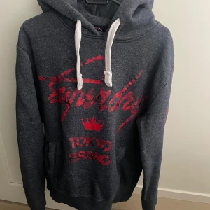 Mörkgrå Superdry hoodie Tokyo Brand - Mörkgrå hoodie från Superdry i storlek i storlek S, modellen är ca 180 cm lång. Hör av dig vid funderingar!