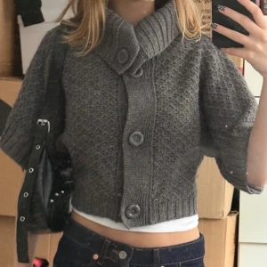 Vintage stickad kofta med stora knappar - Kort grå stickad kofta med bred krage. Perfekt att slänga över en topp för extra värme och stil. Använd några gånger.
