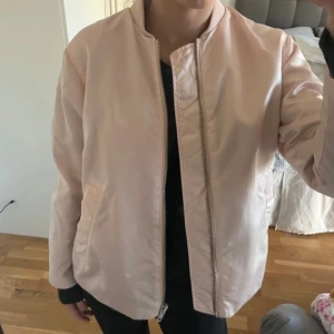 Ljusrosa bomberjacka Peak Performance - Snygg ljusrosa bomberjacka från Peak Performance med glansig finish. Jackan har klassisk bomberkrage, dragkedja framtill och två snedställda fickor. Mycket bra skick!