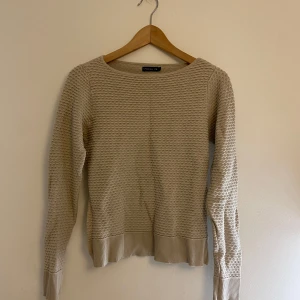 Beige stickad tröja från Stockh LM - Säljer en beige stickad tröja från Stockh LM i storlek S. Tröjan har ett coolt strukturerat mönster över hela ytan, rund halsringning och ribbade muddar vid ärmslut och nederkant. Perfekt för lager-på-lager under hösten och vintern.