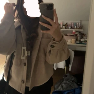 Beige kappa - Snygg beige kappa med två fickor. Jackan har en loose passform och långa ärmar.  Perfekt för lager-på-lager och enkel att styla till olika outfits.