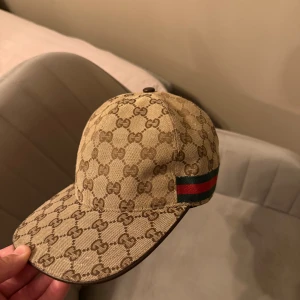 Gucci beige keps med GG-mönster - Säljer Gucci keps, helt äkta finns tyvärr ingen box med då jag fick den av en kompis och han ville ha kvar lådan, använd ett fåtal gånger bara, skriv om pris 