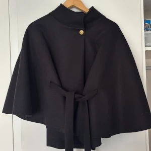 Missäy svart poncho cape kappa - Så fin poncho från missäy, aldrig använd🧡onesize men går att justera med bandet 
