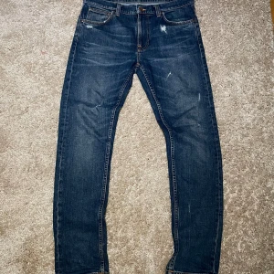 Nudie jeans Lean Dean  - Ett feta par nudie jeans i modellen Lean Dean som sitter slim. Storlek 32 med slitningar och aging i tyget som ger en vintage lock.