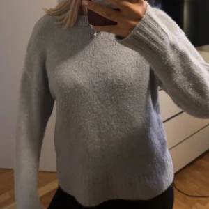 Ljusgrå stickad tröja - Mysig ljusgrå stickad tröja med rund hals och långa ärmar, lite nopprig