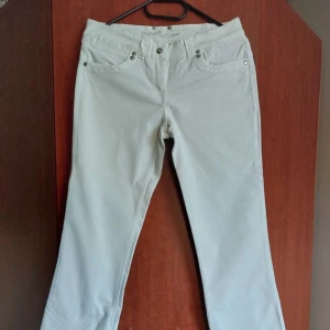 Vita bootcut jeans med detaljer - Snygga vita jeans med bootcut. Säljer då dom inte passar mig längre . 