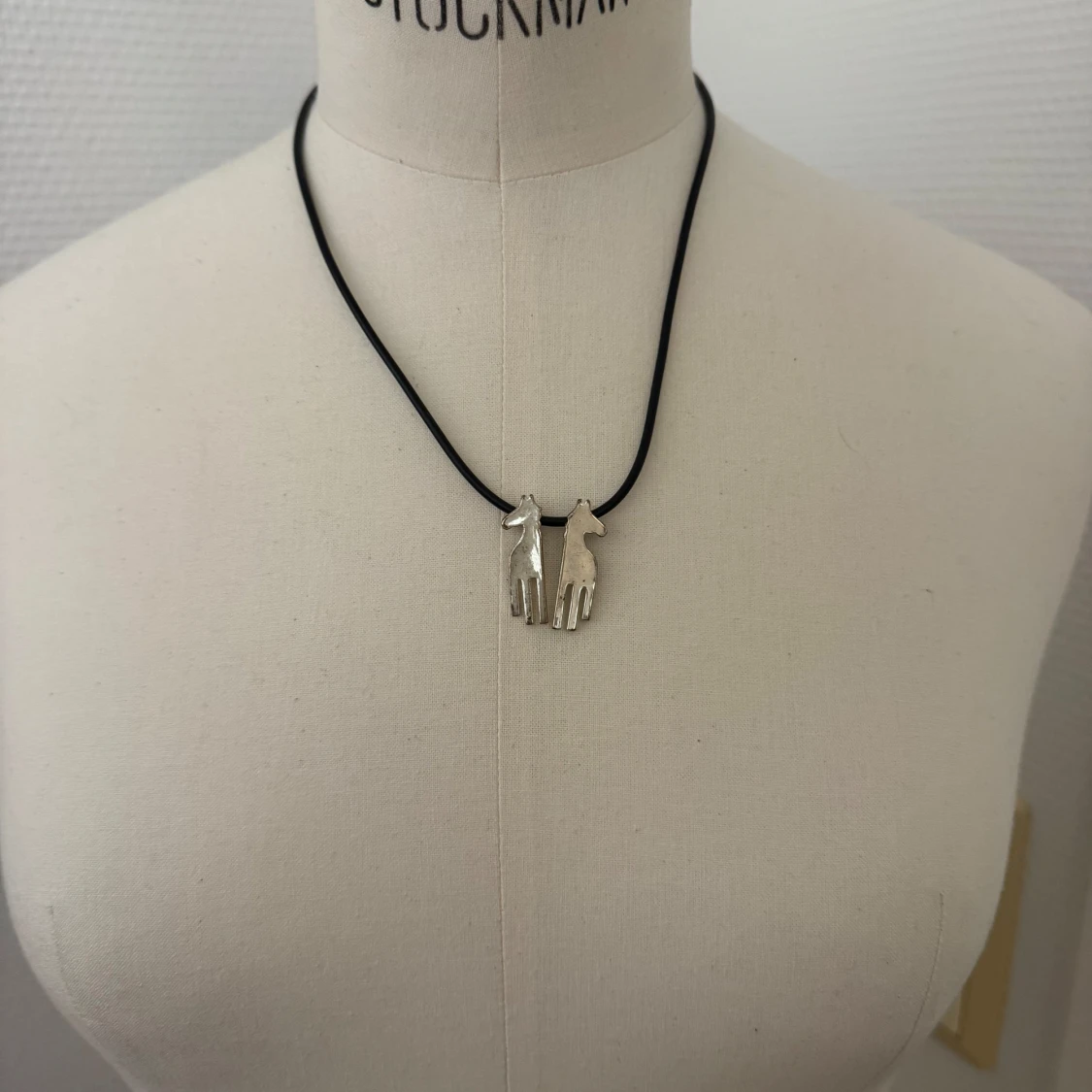 Halsband med silverfärgade hästberlocker