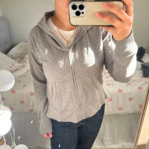 Grå Ralph Lauren zip-hoodie  - Så snygg och mysig zip-hoodie från Ralph Lauren!😍Tröjan har en snygg slits på sidorna. Perfekt nu till hösten! 🍂Skriv för fler bilder eller frågor💕