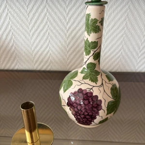 Flaska/ vas med ljusstake - En handmålad flaska eller vas med motiv av vindruvor och gröna blad. Med en guldig ljusstake. Pris för båda