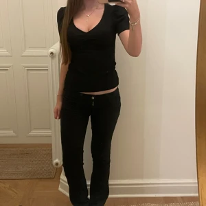 v-ringad topp med puffärm - Säljer en svart topp med v-ringning och korta puffärmar. Modellen är figurnära och har en enkel, stilren design utan mönster eller detaljer. Perfekt för dig som gillar en klassisk och clean look. Superr söt 💓💓