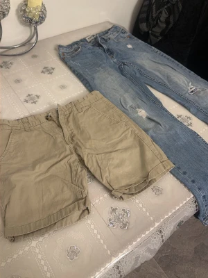 Beige bomullsshorts med fickor 75kr st - Säljer ett par klassiska beige shorts i bomull med normal passform. Shortsen har bälteshällor, knapp och dragkedja framtill samt sidofickor. Perfekta för varma dagar och enkel att matcha med olika stilar.