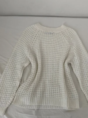 Vit stickad tröja från Lager 157 - Säljer en vit stickad tröja från Lager157 i storlek S. Använd bara två gånger så den är i bra skick. Tröjan har ett grovt, luftigt stickat mönster och ribbade muddar vid hals, ärmslut och nederkant. Perfekt för lager-på-lager under kyliga dagar. Enkel och stilren design som är lätt att matcha.