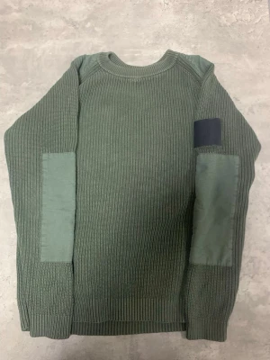 Grön stickad tröja Peak Performance S - Säljer en grön stickad tröja från Peak Performance, modell Curtis Crew. Tröjan har ribbad struktur, förstärkta partier på armbågarna och ett svart Peak Performance-märke på ena ärmen. Rund hals och långärmad, tillverkad av italienskt garn. Kan gå ner i pris vid snabb affär! 