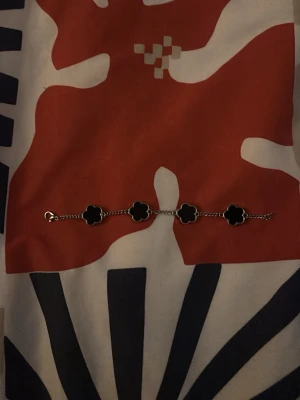 Svart 5 klöver armband  - Säljer en stilren s925 armband som är 4 stycken 5 klöversblad jag köpte o Grekland. Köpte för 20€ men säljer för 150kr