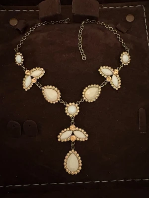 Jätte fin halsband 🤍 - ett halsband med vita och guldiga stenar på 🤍