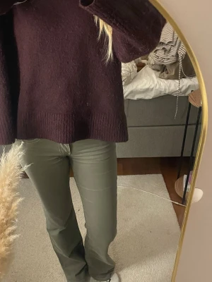 Gröna bootcut jeans med låg midja - Snygga gröna jeans med bootcut-snitt och låg midja. Byxorna har klassiska fem fickor och coola vita sömmar på bakfickorna. Materialet är jeans och färgen är en mörkare grön ton. Perfekta för dig som vill ha en chill och trendig look.