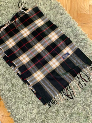 Butbery scarf - Vintage äkta Burberry-scarf i klassiskt rutmönster. Tillverkad i högkvalitativt, mjukt material som ger en lyxig och tidlös känsla. En ikonisk Burberry-accessoar som passar perfekt till både vardag och finare tillfällen.  📦 Snabb frakt 💯 Äkthet garanteras ✨ Redo att användas direkt 