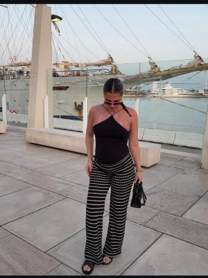 Svartvita stickade wide byxor - Säljer ett par stickade byxor med svart och vitt randigt mönster. Byxorna har en relaxed wide passform och är midwaist. Materialet är stickat och känns mjukt mot huden. Använd 1 gång utan defekter 