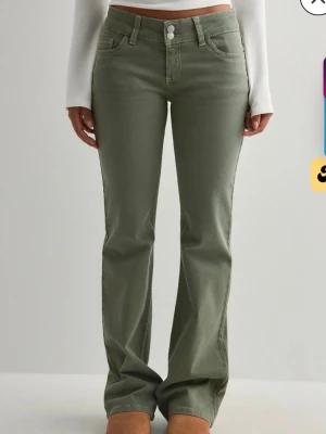 Gröna bootcut jeans från Nelly - Säljer dessa super fina och trendiga jeans ifrån Nelly då jag tyvärr inte får någon användning för dem. Använda fåtal gånger och har lite slitningar längst nere vid foten pga för långa! Kostar 699kr nya